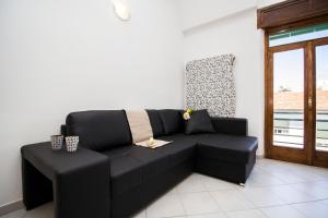 - un canapé noir dans une chambre avec fenêtre dans l'établissement InnPisaRentals - Charme Pisa Toscana 1, à Pise