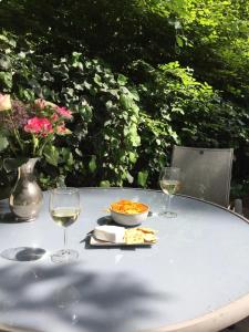 een tafel met een kom eten en twee glazen wijn bij Vogelzang in Hattemerbroek