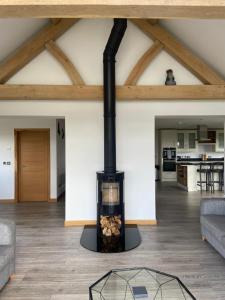 una chimenea en la sala de estar de una casa en The Cottage - spacious getaway with stunning views, en Auchenblae