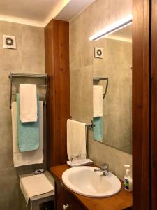 a bathroom with a sink and a mirror and towels at Casa do Largo - Açores in Ponta Delgada