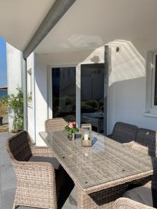 una mesa y sillas en un patio con una vela en Villa Mare Meerblick en Glücksburg