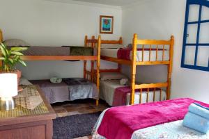 a room with three bunk beds and a table at Fazenda da Luz in Vassouras