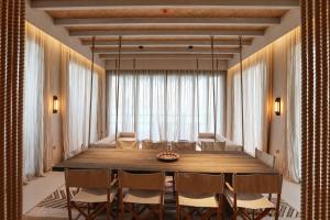una sala da pranzo con un grande tavolo e sedie in legno di The Chedi Katara Hotel & Resort a Doha Altre 37 foto