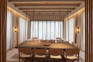 una sala da pranzo con un grande tavolo in legno e sedie di The Chedi Katara Hotel & Resort a Doha