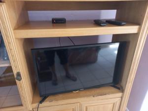 a tv in a wooden cabinet with a persons foot in it at Mia Haven 2 in Scottburgh