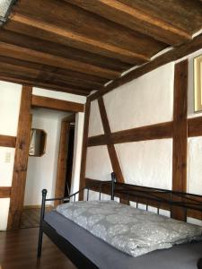 a bedroom with a bed in a room with wooden ceilings at Altstadtpension Zirndorf in Zirndorf
