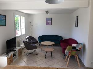 ein Wohnzimmer mit Stühlen, einem Tisch und einem Sofa in der Unterkunft l’ Amont in Étretat