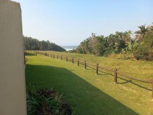 a wooden fence on the side of a grass field at Mia Haven 2 in Scottburgh