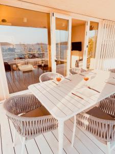 a white dining table and chairs on a balcony at BUQEZ ECO RESORT - Beach Villa 81 - 1st Sea Line by beach in Drage