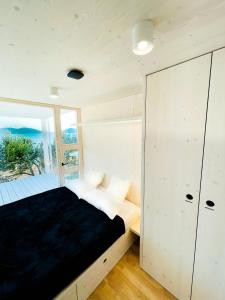 una camera da letto con un letto e una grande finestra di BUQEZ ECO RESORT - Beach Villa 81 - 1st Sea Line by beach a Drage