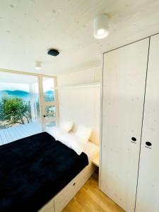 a bedroom with a bed and a large window at BUQEZ ECO RESORT - Beach Villa 81 - 1st Sea Line by beach in Drage