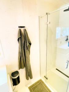 e bagno con doccia e asciugamano sullo scaffale. di BUQEZ ECO RESORT - Beach Villa 81 - 1st Sea Line by beach a Drage