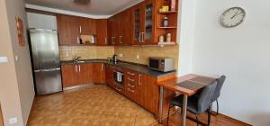 een keuken met houten kasten en een klok aan de muur bij Apartmán P+Z in Znojmo