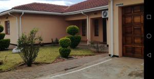 una casa con una puerta y algunos arbustos en DEN VIEW GUESTHOUSE, en Francistown 8 fotos más