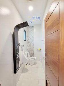 ein Badezimmer mit einem WC und einer Holztür in der Unterkunft Anping Morning in Anping