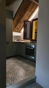 a kitchen with green cabinets and a tile floor at Civico Otto7 in Villasimius