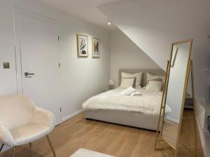 1 dormitorio con cama, espejo y silla en MazuryDreamHouse, en Pelnik