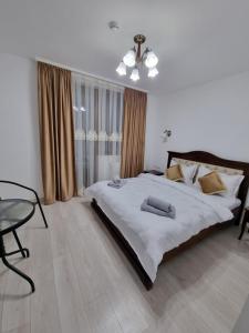 a bedroom with a large bed and a table at Pensiunea Sofia in Onceşti