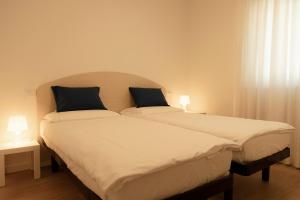 two beds sitting next to each other in a bedroom at HOLIDAY APARTMENTS GIULIA - Blue in Pietramurata