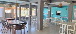 um restaurante com mesas e cadeiras e uma parede azul em Pousada Bem Me Quer em Ilhéus