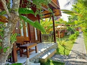 a porch of a house with a table and chairs at Exotic View Cottage in Nusa Penida