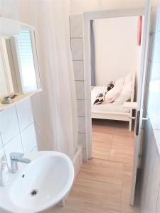 ein Bad mit einem Waschbecken, einem Spiegel und einem Bett in der Unterkunft Studio apartman Marley in Gradac
