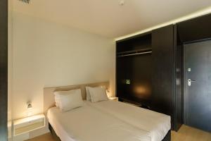 - une chambre avec un lit blanc et une armoire noire dans l'établissement N Apartments - Chã, à Porto