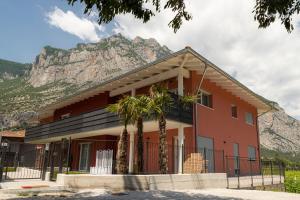 a building with palm trees in front of a mountain at HOLIDAY APARTMENTS GIULIA - Blue in Pietramurata