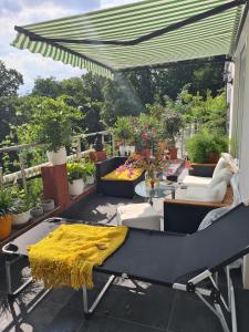 a patio with a table with a yellow blanket on it at Cozy room with a beautiful garden view in Baunatal