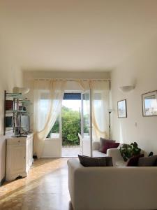 a living room with a white couch and a sliding glass door at Hotel Bencista' in Marina di Pietrasanta