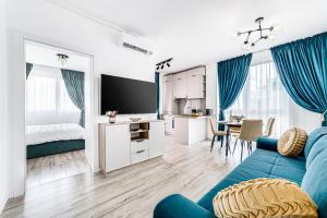 een woonkamer met een blauwe bank en een slaapkamer bij ARI Turquoise Apartment in ARED in Arad
