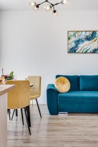 een woonkamer met een blauwe bank en een tafel bij ARI Turquoise Apartment in ARED in Arad