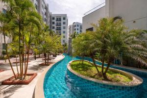 a resort swimming pool with palm trees and buildings at Rare XXXL Swimming Pools Resort - Free Fast WIFI - Top Floor Pool View Balcony in Pattaya South