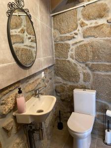 a stone bathroom with a toilet and a sink at Casa da Pipela 