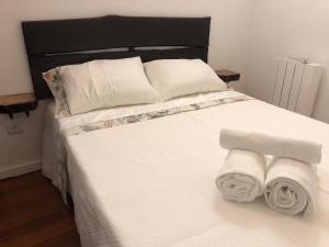 a bed with white sheets and towels on it at Casa da Pipela 