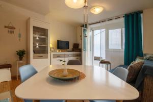 a living room with a white table and blue chairs at Jurkovica in Komiža