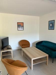 uma sala de estar com um sofá e uma mesa em l’ Aval em Étretat