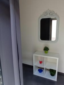 Habitación con mesa blanca y espejo. en Casa Oliver, en Palazzolo Acreide