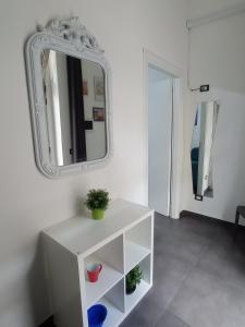 un armario blanco con un espejo en la pared en Casa Oliver, en Palazzolo Acreide