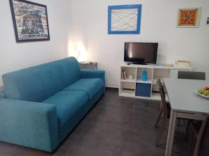 sala de estar con sofá azul y mesa en Casa Oliver, en Palazzolo Acreide