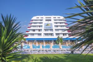 a hotel with a pool and chairs and a building at Hotel Montemar Maritim in Santa Susanna