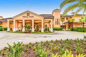 a building with palm trees in front of it at Modern Retreat at Regal Oaks Resort in Orlando