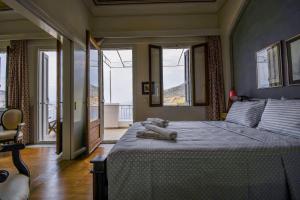 a bedroom with a large bed with large windows at anoi tholos in Symi
