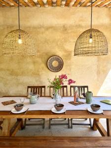 - une table en bois avec des assiettes et des fleurs dans l'établissement Domaine de la Bastidonne, à Céreste