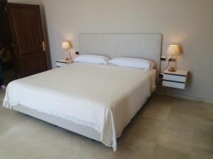 a bedroom with a large white bed with two lamps at Villa Celia in Candelaria +45 photos