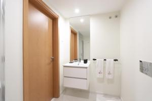 a white bathroom with a sink and a mirror at HM - ISSY Oporto Apartment in Porto +27 photos