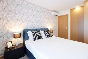 a bedroom with a large bed and a wall at HM - ISSY Oporto Apartment in Porto