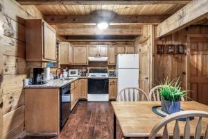 a kitchen with wooden cabinets and a white refrigerator at Beary Patch Hill Hot Tub 9 Miles to Great Smoky Mtn National Park in Sevierville