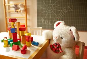 a teddy bear sitting next to a table with toys at Gstaaderhof - Active & Relax Hotel in Gstaad