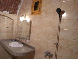 a bathroom with a sink and a mirror at Rahala Safari Hotel in Qasr Al Farafirah